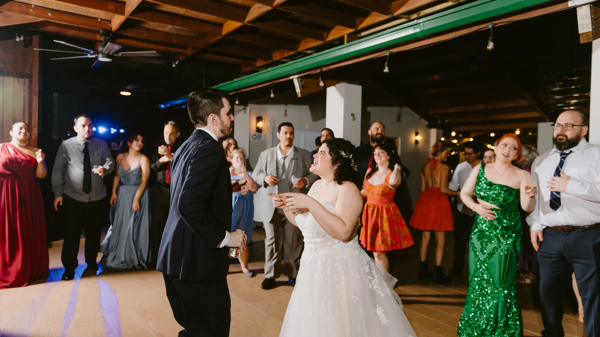 Couple dancing with guests on a wedding reception dance floor
