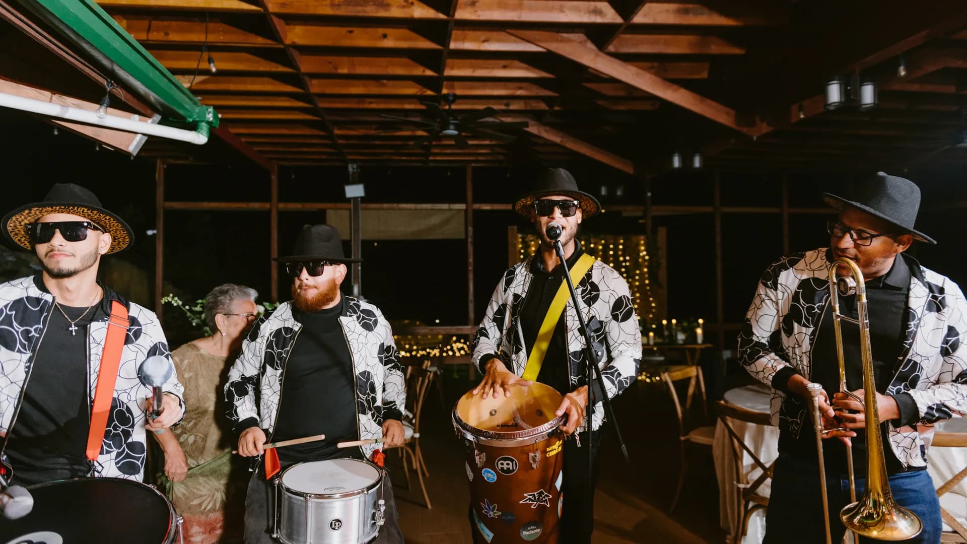 Músicos de batucada con tambores y trombón en una recepción