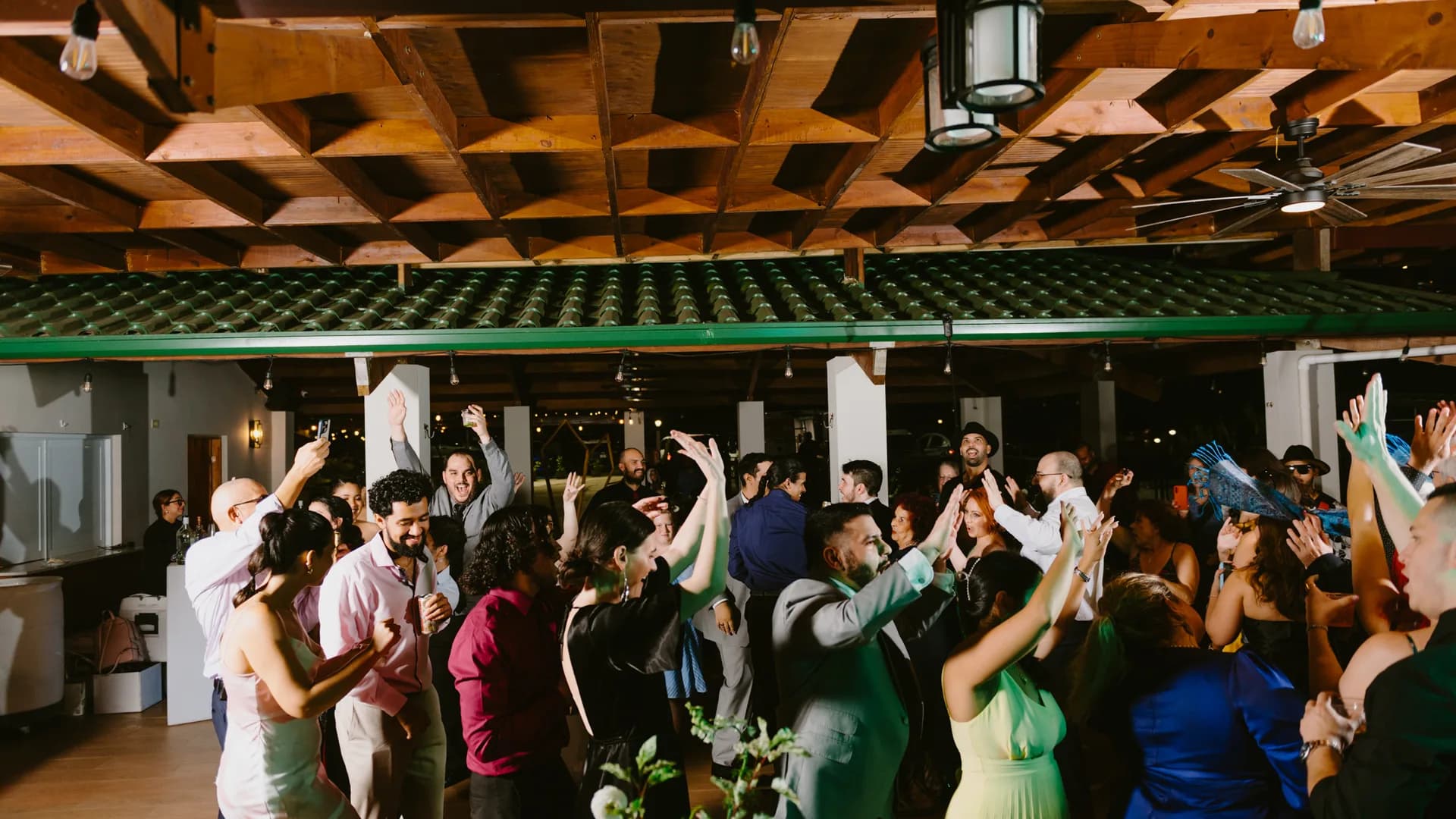Guests dancing with raised arms at a reception