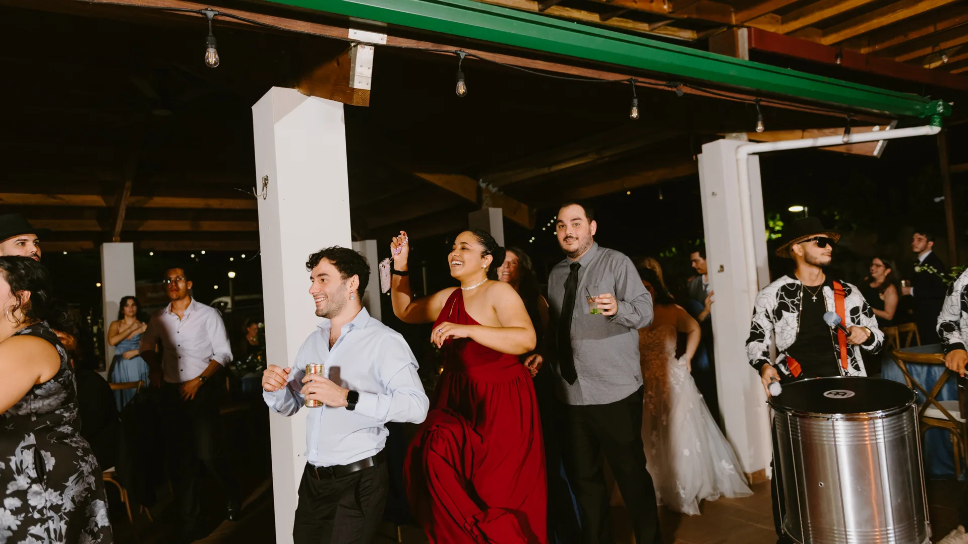 Invitados bailando junto a un músico de batucada en una recepción