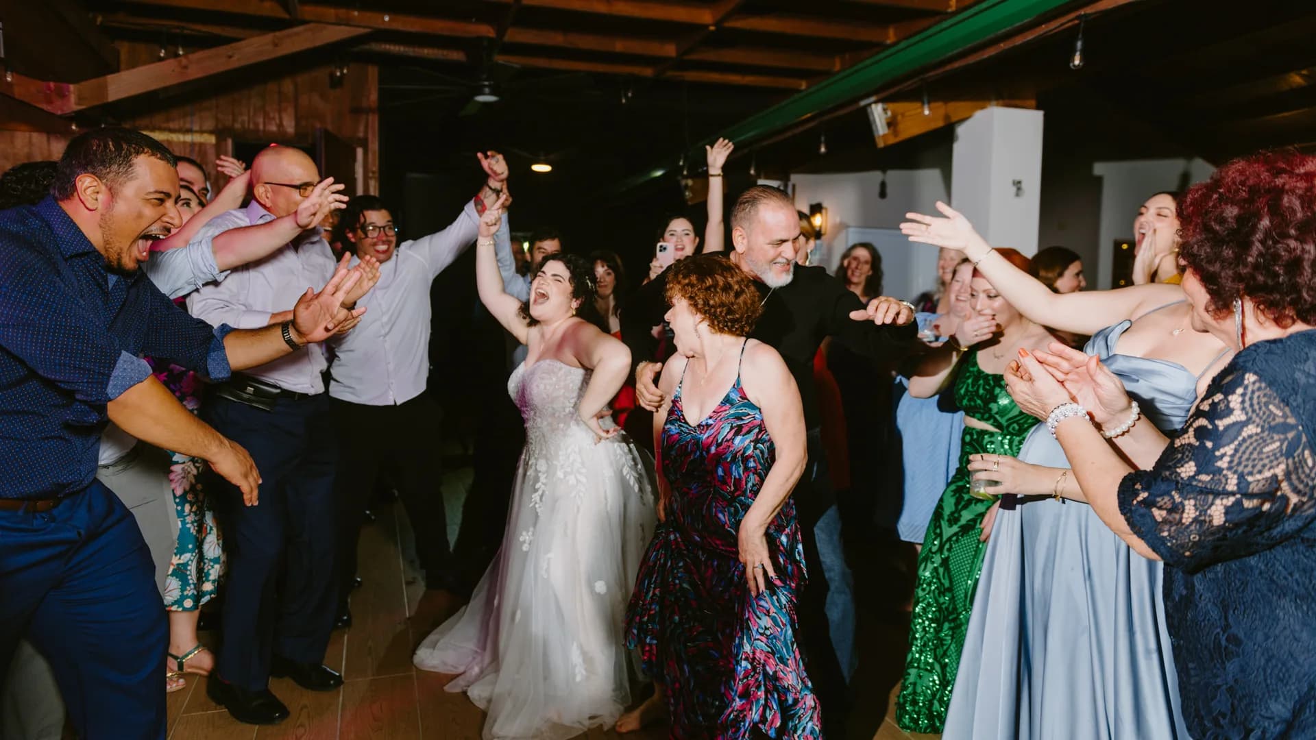 Bride and guests dancing together at a reception
