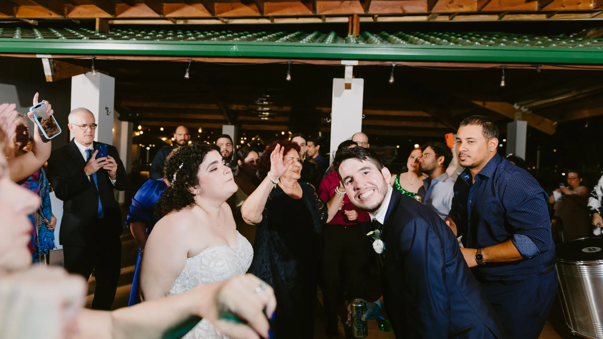 Bride and groom dancing among guests at a reception