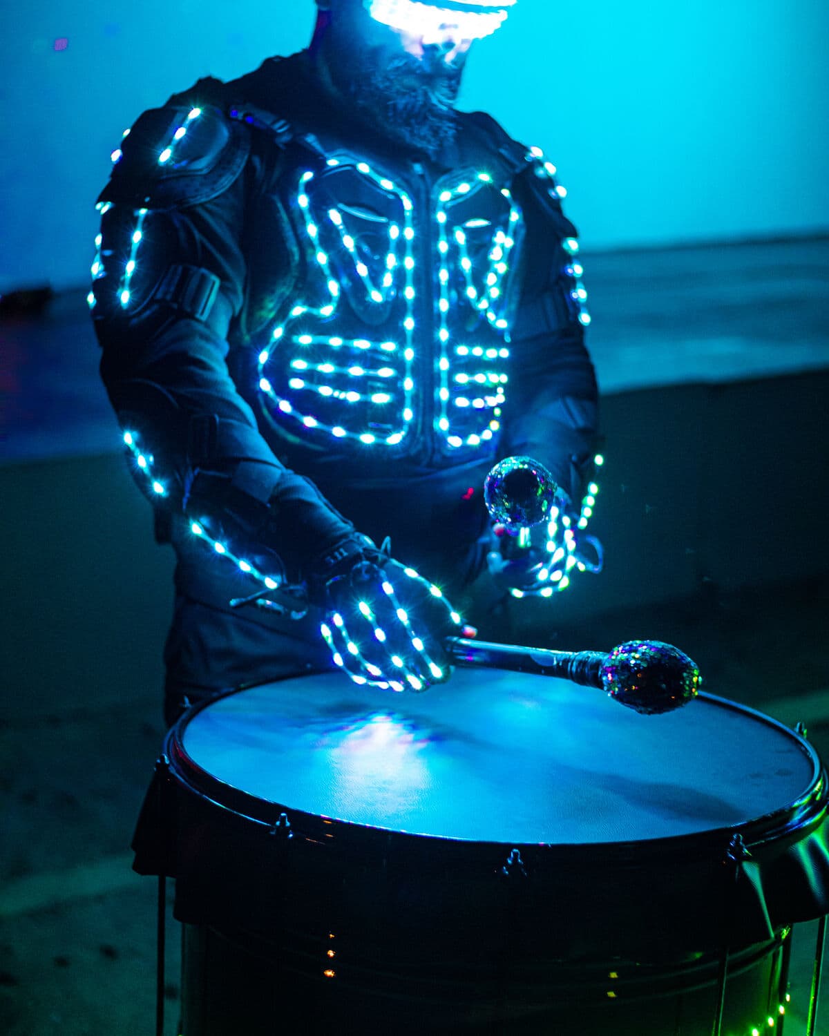 Percusionista con traje LED tocando un tambor iluminado