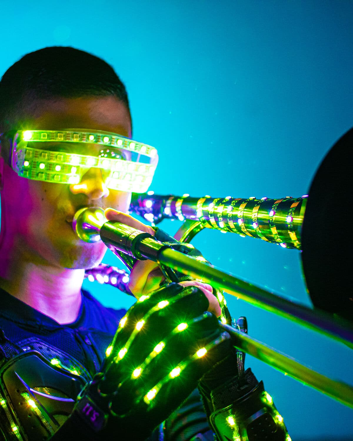 Trombonista con gafas y traje LED en plena presentación
