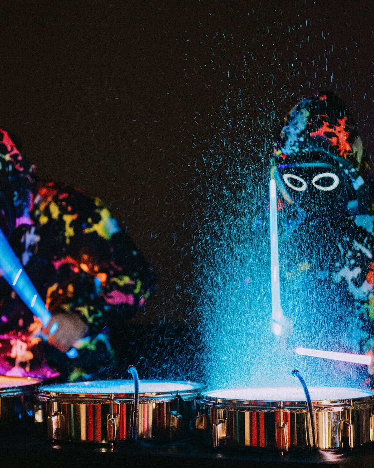 Agua iluminada saltando de los tambores en un show de Splash Drummers